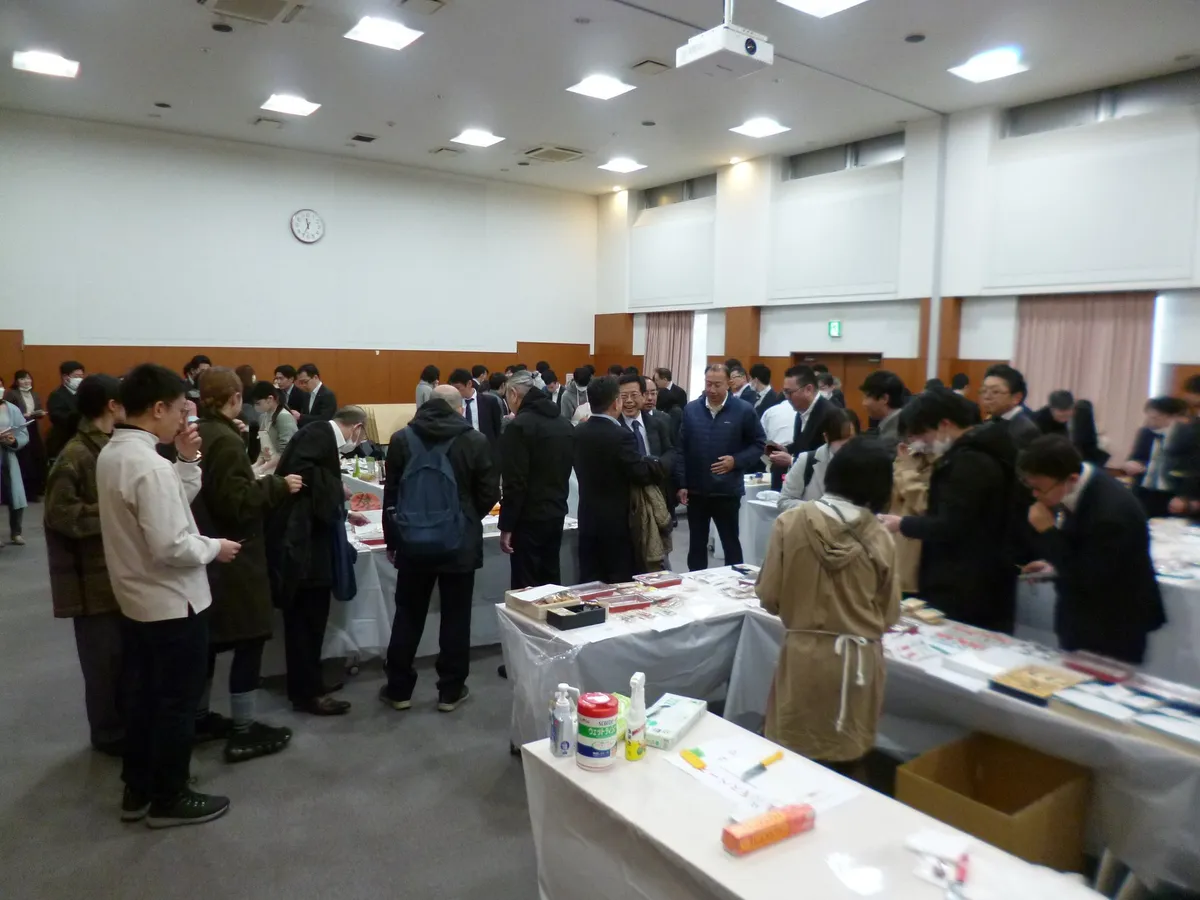 ねり製品が並ぶ会場。長机のまわりに来場者が集まり、並んだ商品を見ている。